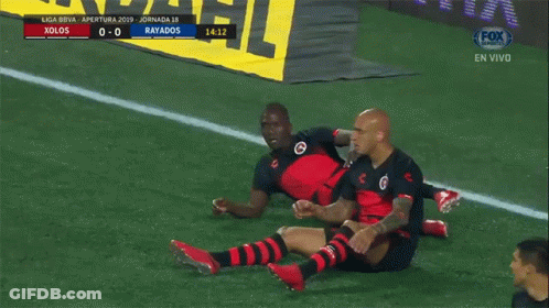 Two Soccer Players Are Celebrating A Goal In Front Of A Sign That Says Fox Sports GIF
