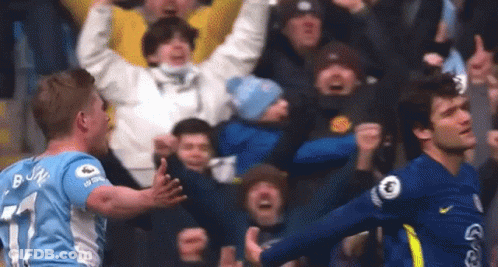 Two Soccer Players Are Celebrating A Goal In Front Of The Crowd . GIF