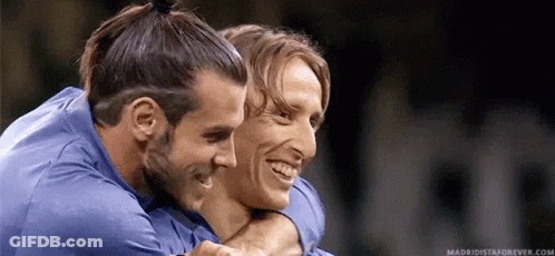 Two Soccer Players Are Hugging Each Other And Smiling . GIF