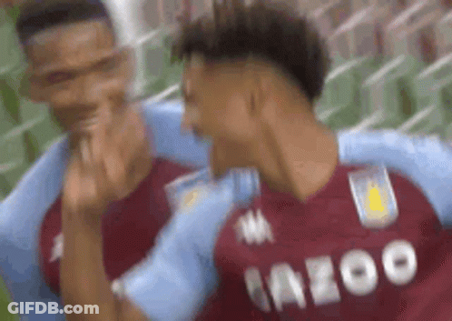 Two Soccer Players Are Hugging Each Other On A Field And Giving The Middle Finger . GIF