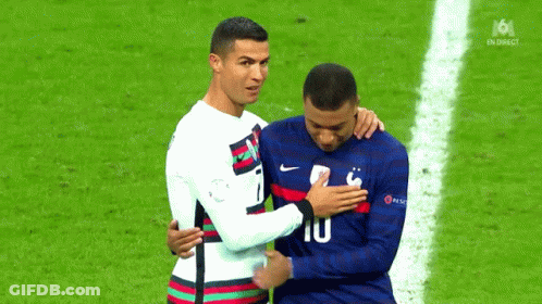 Two Soccer Players Are Hugging Each Other On A Field . GIF