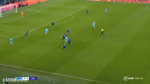 Two Soccer Players Are Hugging Each Other On A Field With A Score Of 5-0 On The Screen GIF
