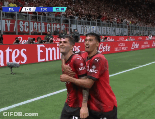 Two Soccer Players Are Hugging Each Other On A Field With An Emirates Advertisement Behind Them GIF