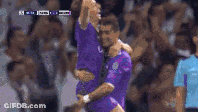 Two Soccer Players Are Hugging Each Other On The Field . GIF