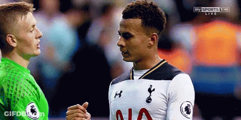 Two Soccer Players Are Shaking Hands On A Field During A Game . GIF