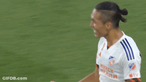 Two Soccer Players Are Shaking Hands On A Field . GIF