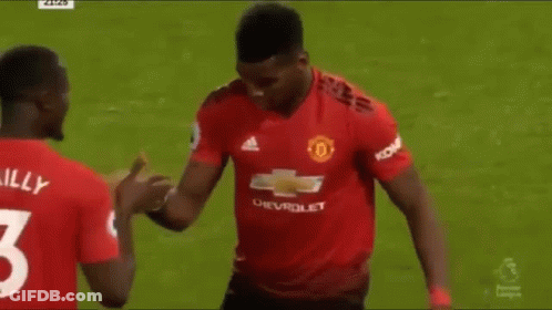 Two Soccer Players Are Shaking Hands On The Field During A Match . GIF
