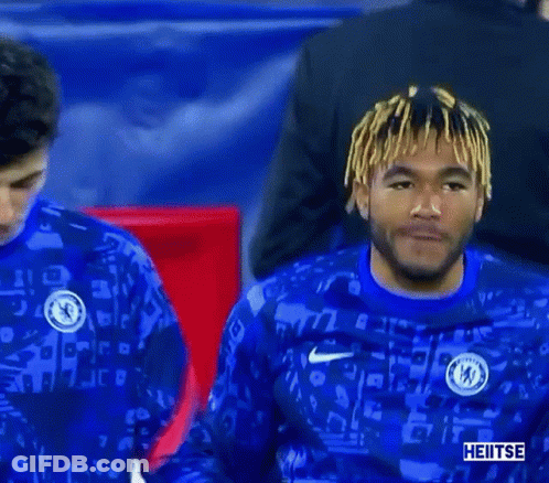 Two Soccer Players Are Shaking Hands On The Field While Wearing Blue Jerseys . GIF