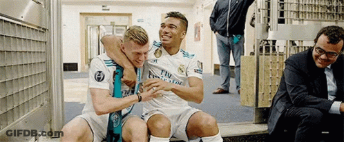 Two Soccer Players Are Sitting Next To Each Other In A Locker Room . GIF