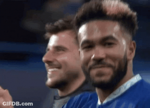 Two Soccer Players Are Smiling And Clapping Their Hands While Standing Next To Each Other . GIF