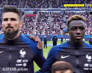 Two Soccer Players Are Standing Next To Each Other On A Field . GIF