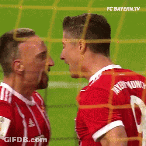 Two Soccer Players Are Standing Next To Each Other On The Field And Looking At Each Other . GIF