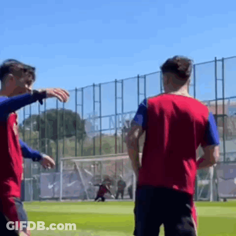 Two Soccer Players Are Standing On A Field And One Of Them Is Pointing At The Other . GIF