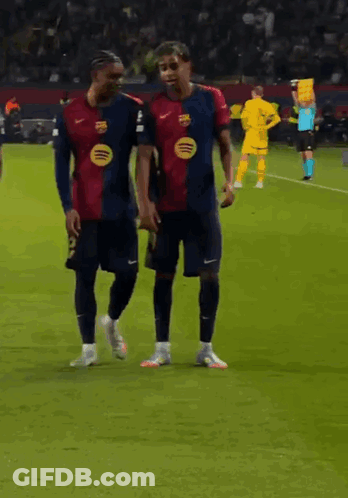 Two Soccer Players Are Walking On The Field And One Has A Spotify Logo On His Jersey GIF