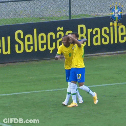Two Soccer Players Celebrate In Front Of Selecao Brasile Sign GIF