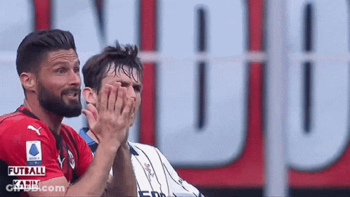 Two Soccer Players Clapping In Front Of Futball Karim Sign GIF