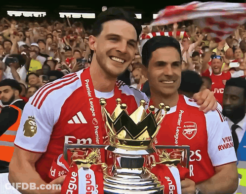 Two Soccer Players Holding A Trophy With The Word Premier League On Their Shirts GIF