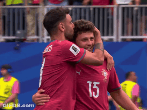 Two Soccer Players Hugging Each Other With One Wearing The Number 15 GIF
