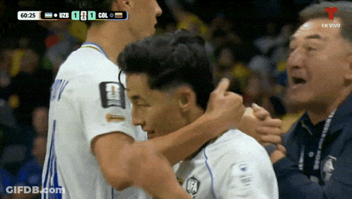 Two Soccer Players Hugging In Front Of 60:25 Scoreboard GIF