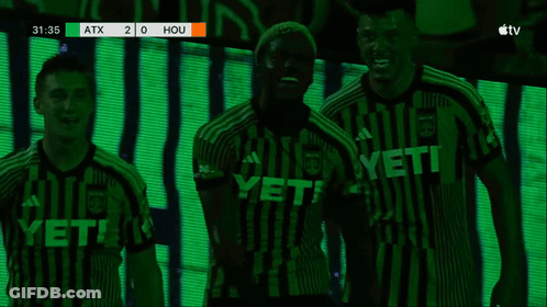 Two Soccer Players Hugging In Front Of Scoreboard Saying Hou GIF
