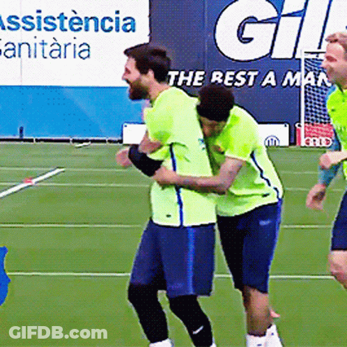 Two Soccer Players Hugging On A Field With A Sign That Says ' Assistance Sanitaria ' In The Background GIF