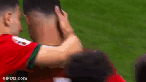Two Soccer Players Hugging, One Touching Head GIF