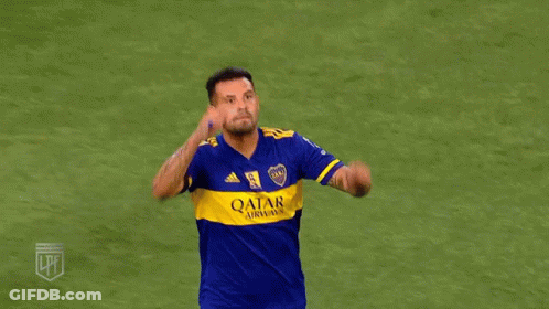 Two Soccer Players In Blue And Yellow Jerseys Are Hugging Each Other On A Field . GIF