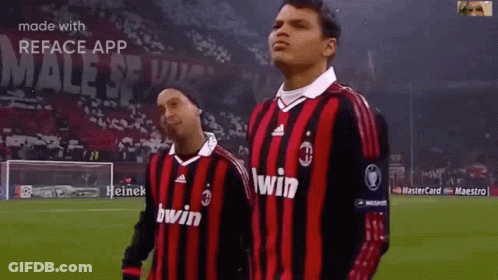 Two Soccer Players In Red And Black Jerseys Saying Win GIF