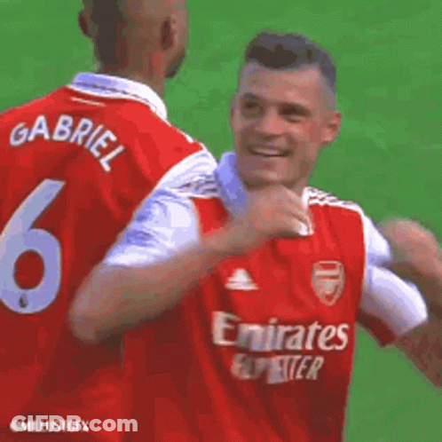 Two Soccer Players In Red Jerseys Hugging GIF