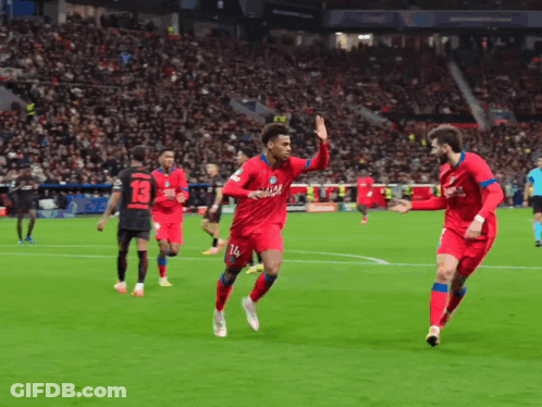 Two Soccer Players In Red Qatar Jerseys Celebrate GIF