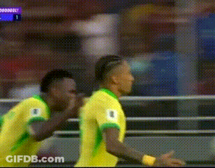 Two Soccer Players In Yellow And Green Jerseys Celebrating Goal GIF