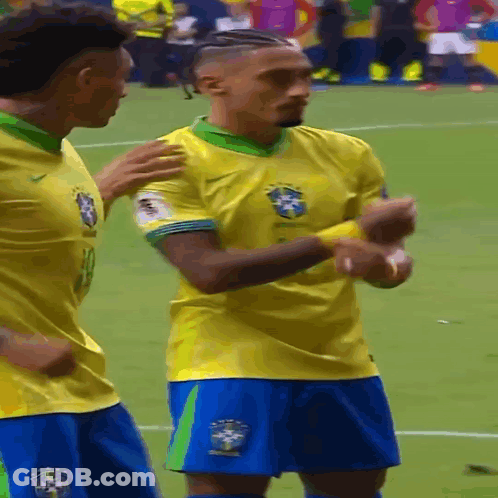 Two Soccer Players In Yellow Jerseys And Blue Shorts GIF