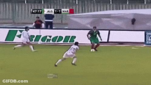 Two Soccer Players On A Field With A Sign That Says Ricor On It GIF