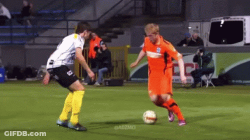 Two Soccer Players On A Field With Adzmci In The Corner GIF