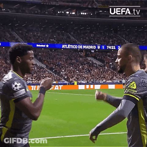Two Soccer Players Shake Hands On A Field With Uefa.tv In The Upper Right Corner GIF