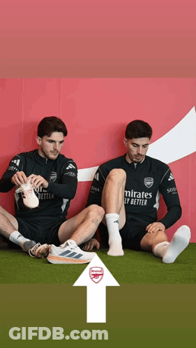 Two Soccer Players Sitting, One Wearing Emirates Fly Better GIF