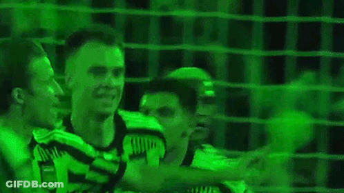 Two Soccer Players Standing In Front Of Green Background GIF