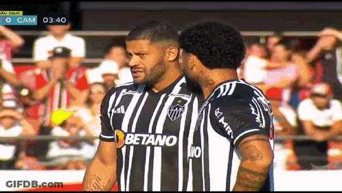 Two Soccer Players Wearing Betano Jerseys Are Standing Next To Each Other On A Field GIF