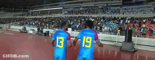 Two Soccer Players Wearing Blue Jerseys With The Number 13 And 19 On Them GIF