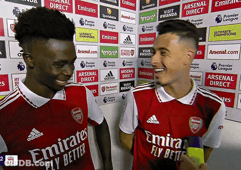 Two Soccer Players Wearing Emirates Fly Better Jerseys Are Talking To Each Other GIF
