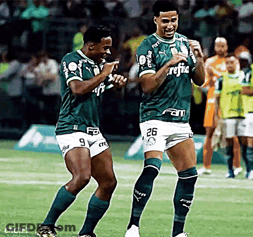 Two Soccer Players Wearing Green Jerseys With The Number 26 On The Shorts GIF