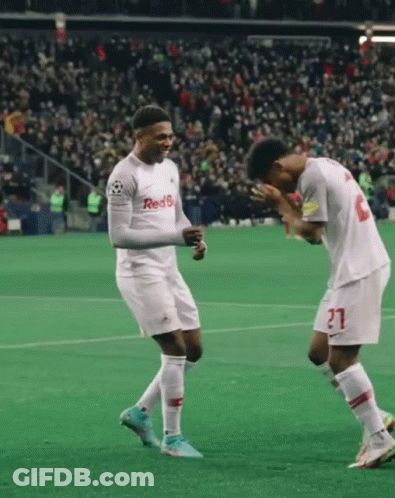 Two Soccer Players Wearing Red 6 Jerseys Celebrate On A Field GIF