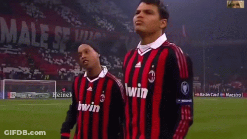 Two Soccer Players Wearing Red And Black Striped Jerseys With The Word Bwin On Them GIF