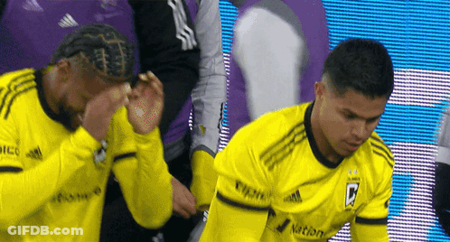 Two Soccer Players Wearing Yellow Jerseys With The Letter B On The Front GIF