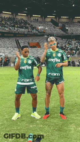 Two Soccer Players With Crefisa On Their Shirts Stand On The Field GIF