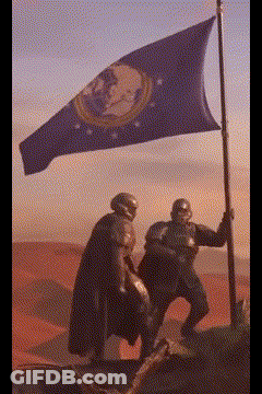 Two Soldiers Are Holding A Flag In A Desert GIF