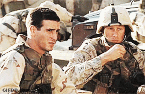 Two Soldiers Are Sitting Next To Each Other And One Is Wearing A Helmet That Says ' Us Marines ' On It GIF