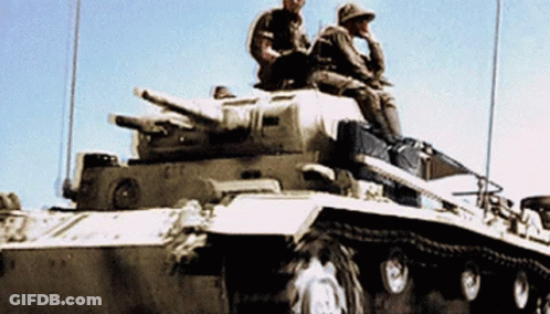 Two Soldiers Are Sitting On Top Of A Tank With A Blue Sky In The Background GIF