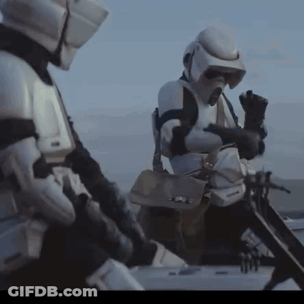 Two Storm Trooper Soldiers Are Standing Next To Each Other In The Desert . GIF