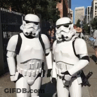 Two Stormtroopers Standing Next To Each Other On A Street GIF